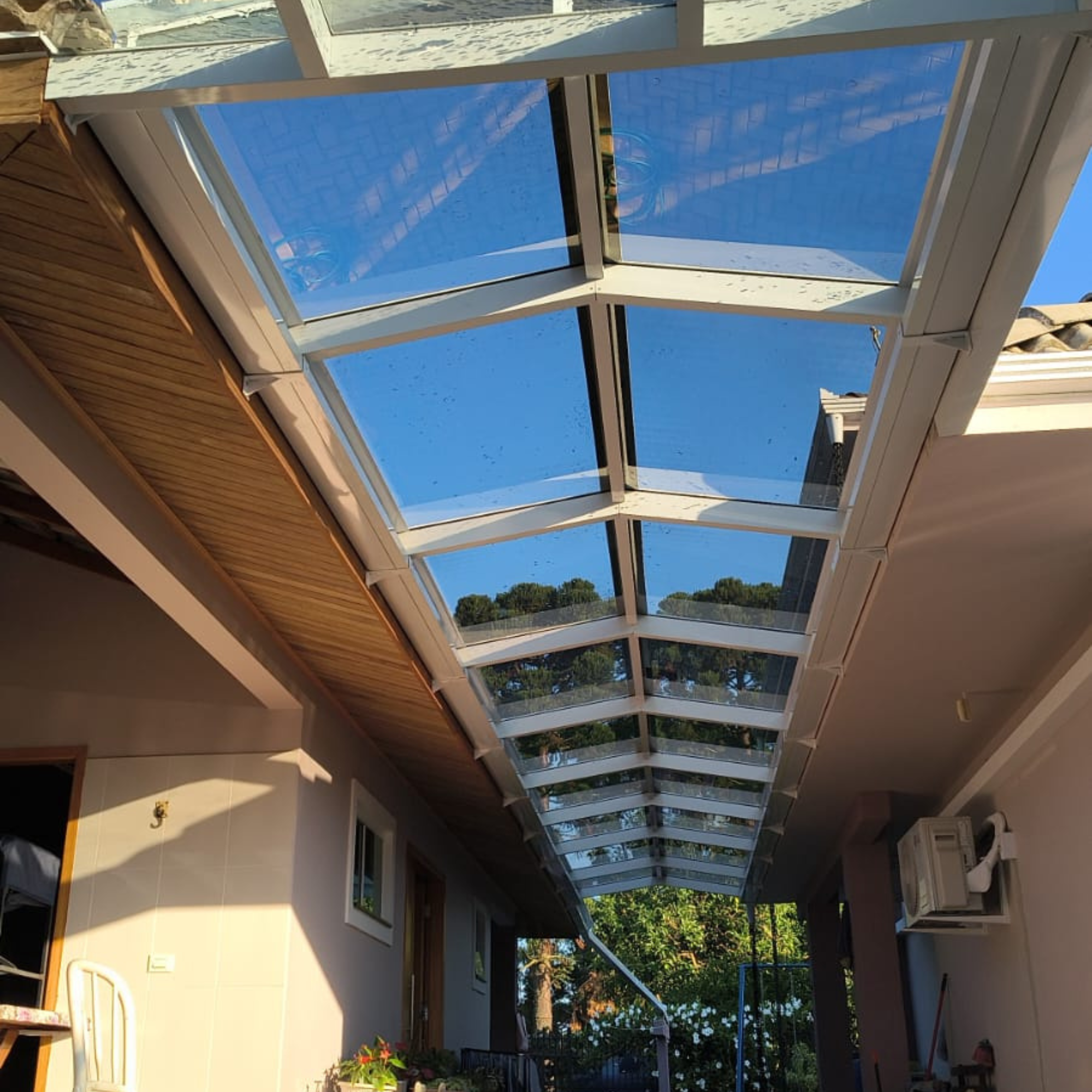 Cobertura em vidro com caimento central e estrutura branca